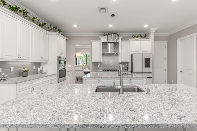 5211 SW Blue Daze Way, Palm City, FL 34990 - kitchen featuring a sink, a large island, stainless steel appliances, wall chimney exhaust hood, and white cabinets