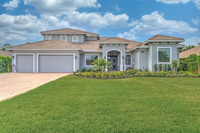 5211 SW Blue Daze Way, Palm City, FL 34990 - mediterranean / spanish-style home featuring an attached garage, a front yard, driveway, stucco siding, and a tiled roof