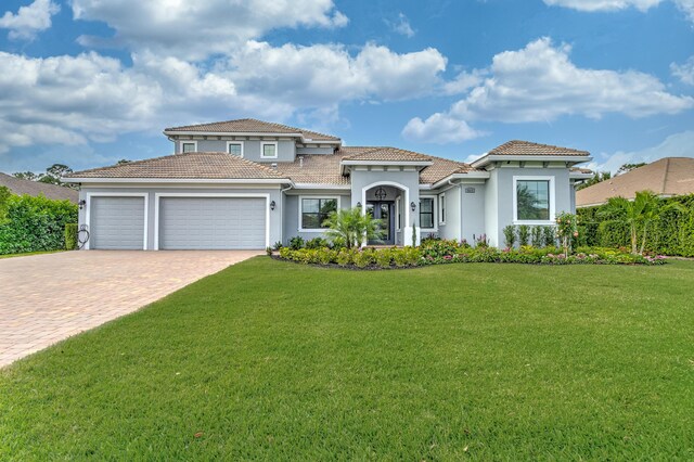 5211 SW Blue Daze Way, Palm City, FL 34990 - mediterranean / spanish-style home with an attached garage, driveway, stucco siding, a front lawn, and a tile roof