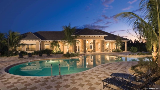 5211 SW Blue Daze Way, Palm City, FL 34990 - pool at dusk featuring a patio area and a community pool