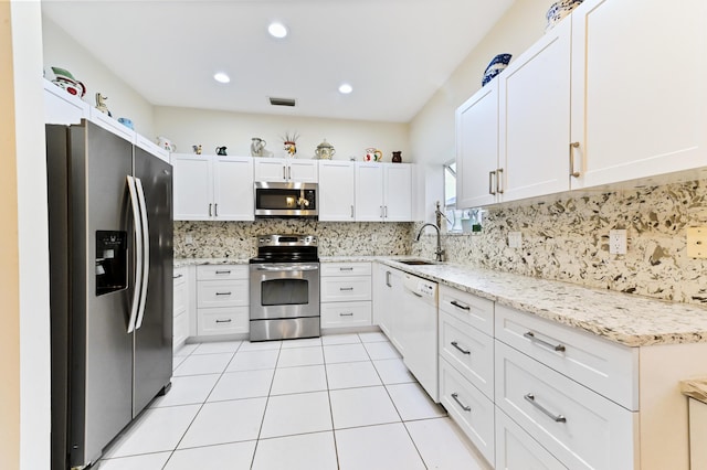 11683 Briarwood Cir Unit 4, Boynton Beach, FL 33437 - kitchen with stainless steel appliances, a sink, tasteful backsplash, white cabinetry, and light stone counters