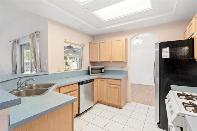 531 SE Evergreen Ter, Port Saint Lucie, FL 34983 - kitchen featuring appliances with stainless steel finishes, light brown cabinets, a sink, light tile patterned flooring, and arched walkways
