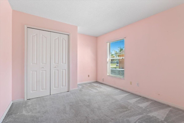 531 SE Evergreen Ter, Port Saint Lucie, FL 34983 - unfurnished bedroom with carpet flooring, a closet, baseboards, and a textured ceiling