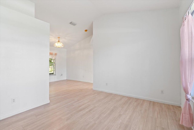 531 SE Evergreen Ter, Port Saint Lucie, FL 34983 - unfurnished room featuring lofted ceiling, a chandelier, light wood-style floors, and baseboards