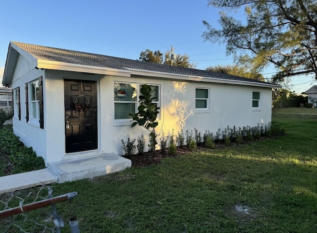view of front facade with a front yard and stucco siding