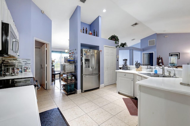 1226 SW San Antonio Ave, Port Saint Lucie, FL 34953 - kitchen featuring stainless steel appliances, a sink, high vaulted ceiling, light tile patterned floors, and light countertops