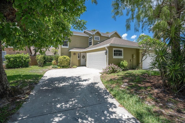 traditional-style home with an attached garage, concrete driveway, and roof with shingles