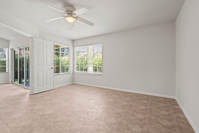 unfurnished room with ceiling fan, light tile patterned floors, and baseboards
