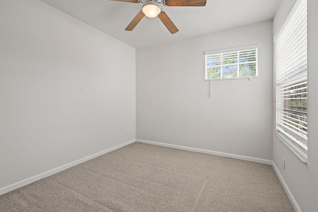unfurnished room featuring light carpet, baseboards, and a ceiling fan