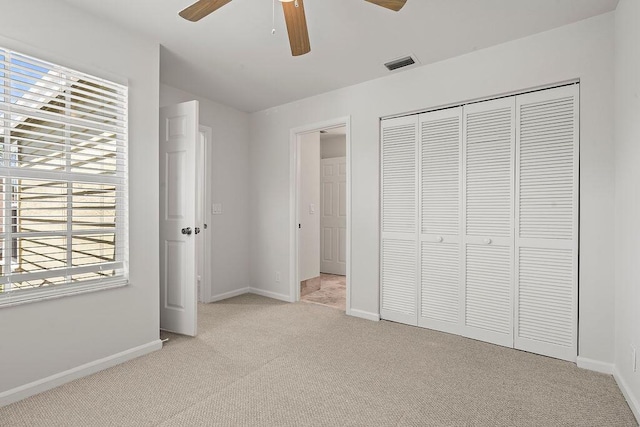 unfurnished bedroom featuring carpet flooring, baseboards, and multiple windows
