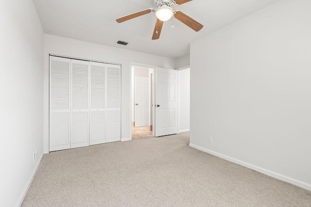 unfurnished bedroom featuring carpet flooring, baseboards, a closet, and ceiling fan