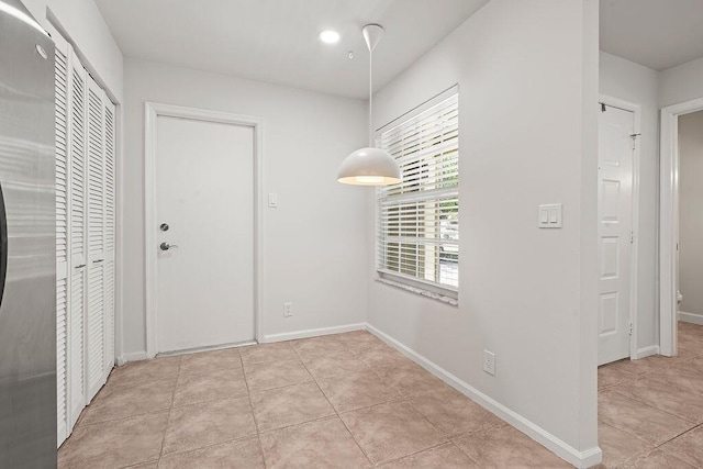 entryway with baseboards and light tile patterned floors