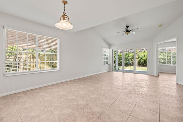 spare room featuring lofted ceiling, a ceiling fan, light tile patterned flooring, and baseboards