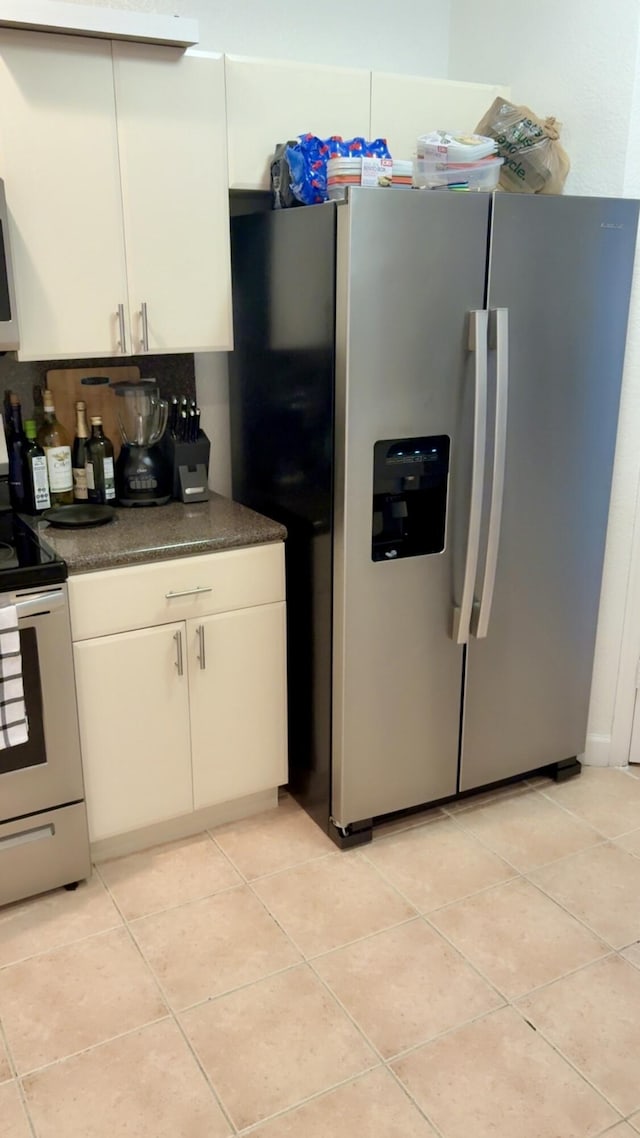 3608 Shoma Dr, Royal Palm Beach, FL 33414 - kitchen featuring stainless steel refrigerator with ice dispenser, range with electric stovetop, dark countertops, light tile patterned floors, and white cabinets