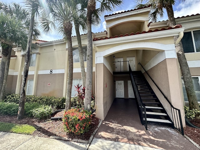 815 W Boynton Beach Blvd Unit 8-204, Boynton Beach, FL 33426 - view of exterior entry with stucco siding and a tile roof