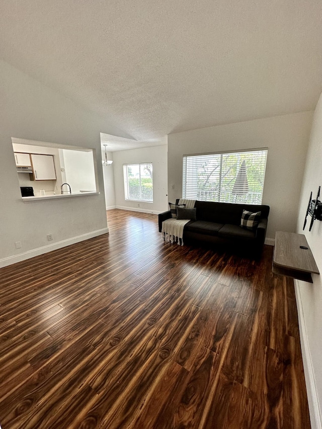 815 W Boynton Beach Blvd Unit 8-204, Boynton Beach, FL 33426 - living area featuring dark wood-style floors, a textured ceiling, baseboards, and a chandelier