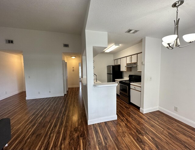 815 W Boynton Beach Blvd Unit 8-204, Boynton Beach, FL 33426 - kitchen featuring appliances with stainless steel finishes, under cabinet range hood, a chandelier, dark wood finished floors, and white cabinets