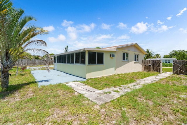 back of house featuring a patio, a sunroom, and a gate