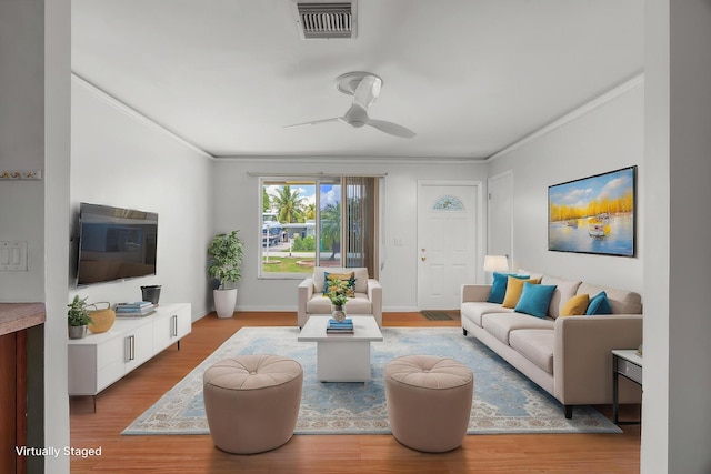 living room with ceiling fan, ornamental molding, wood finished floors, and baseboards