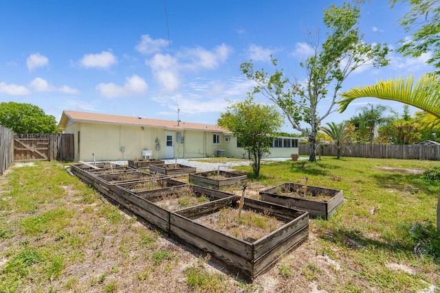 rear view of property featuring a vegetable garden