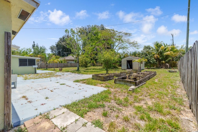 view of yard with a patio area, a vegetable garden, a storage shed, and an outdoor structure