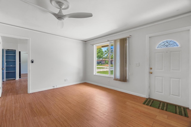 entrance foyer featuring light wood-type flooring, baseboards, ceiling fan, and crown molding