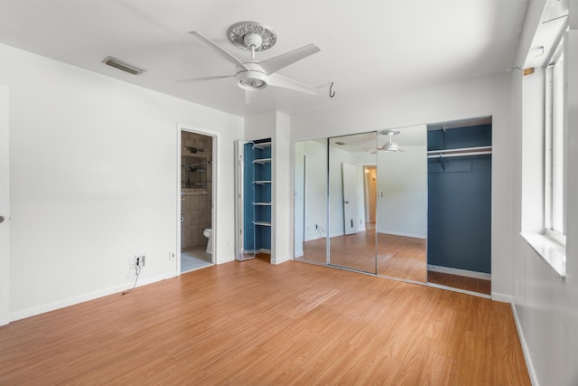 unfurnished bedroom with light wood-style flooring, baseboards, a ceiling fan, and ensuite bathroom