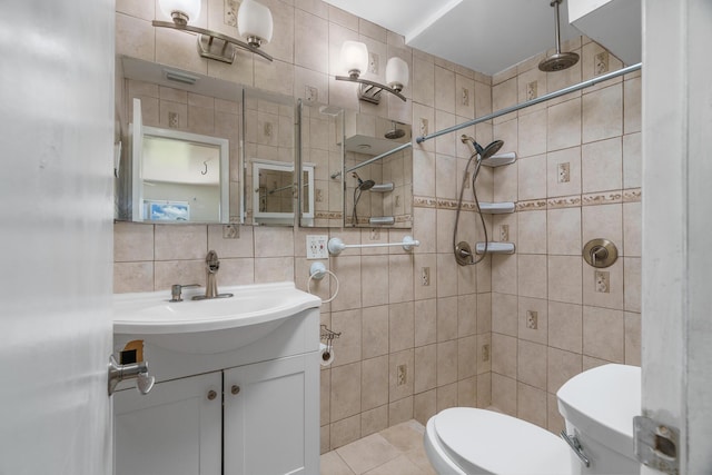bathroom with tile walls, toilet, tiled shower, vanity, and decorative backsplash