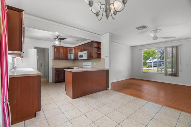 kitchen featuring white microwave, electric stove, ceiling fan, a sink, and a peninsula