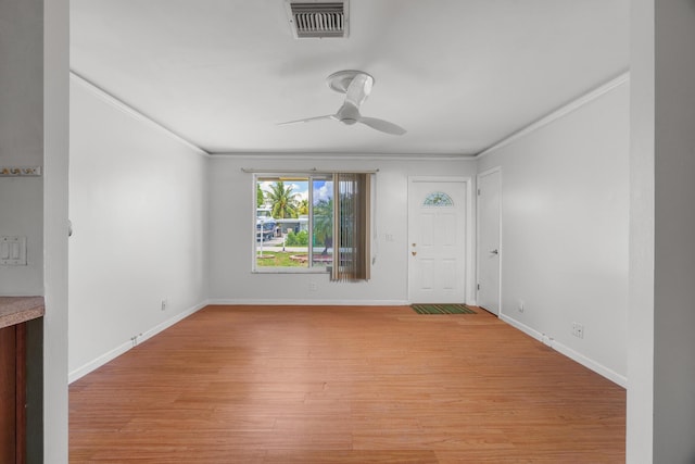 unfurnished room featuring a ceiling fan, ornamental molding, light wood-type flooring, and baseboards
