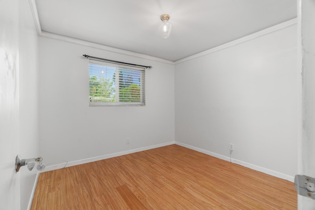 empty room with baseboards, ornamental molding, and light wood-type flooring