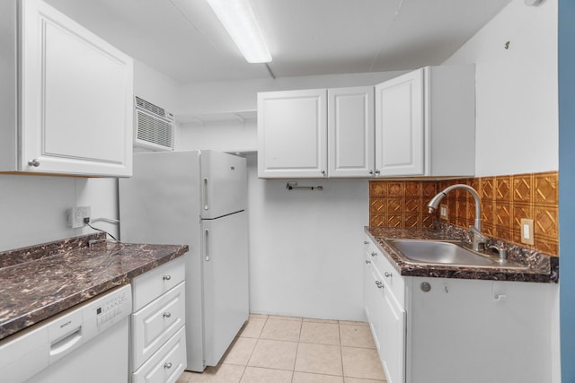kitchen with white appliances, a sink, white cabinets, light tile patterned floors, and a wall unit AC