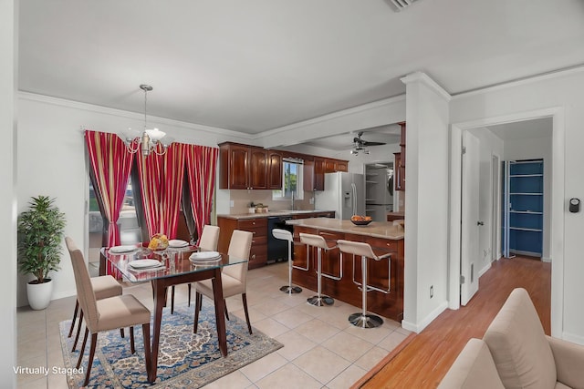 dining space with a chandelier, ceiling fan, crown molding, light tile patterned flooring, and baseboards