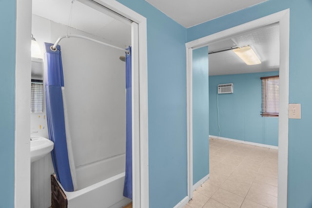 full bathroom with a wall mounted AC, tile patterned flooring, baseboards, and  shower combination