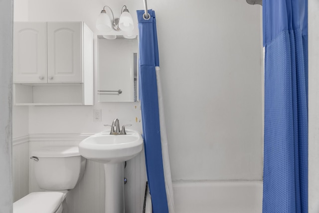 full bathroom with toilet and shower / bath combo with shower curtain