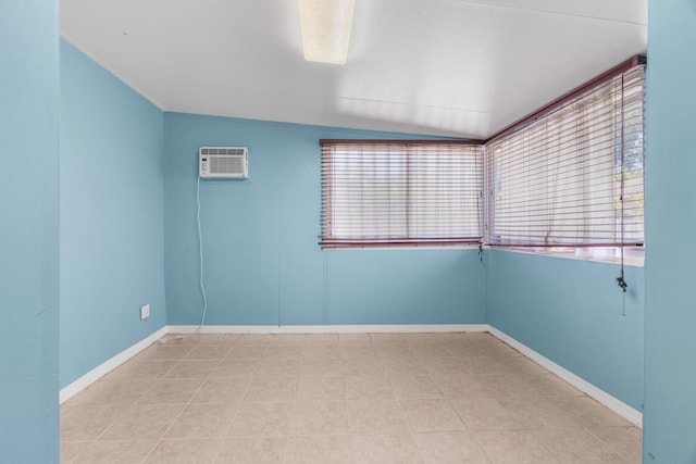 spare room with a wall unit AC and baseboards