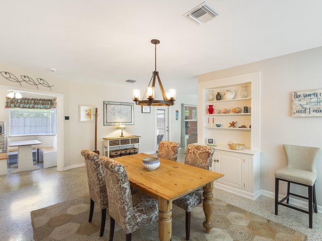 1001 N Lakeside Dr, Lake Worth Beach, FL 33460 - dining space with a chandelier, baseboards, built in shelves, and dark aggregate flooring
