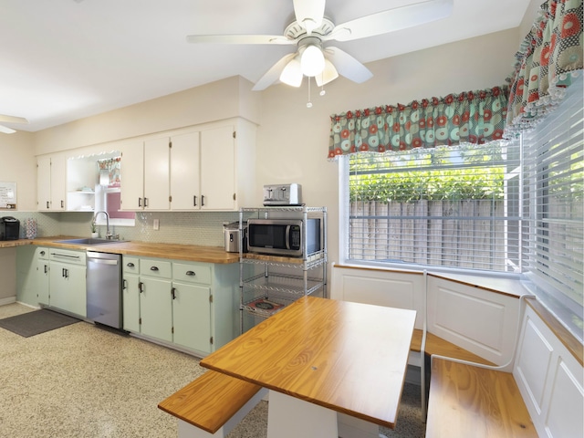 1001 N Lakeside Dr, Lake Worth Beach, FL 33460 - kitchen with appliances with stainless steel finishes, a ceiling fan, butcher block counters, a sink, and tasteful backsplash
