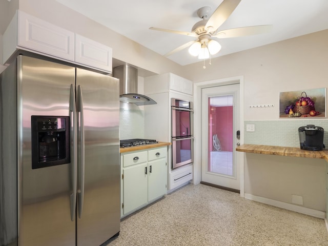 1001 N Lakeside Dr, Lake Worth Beach, FL 33460 - kitchen featuring stainless steel appliances, wall chimney range hood, backsplash, ceiling fan, and white cabinetry