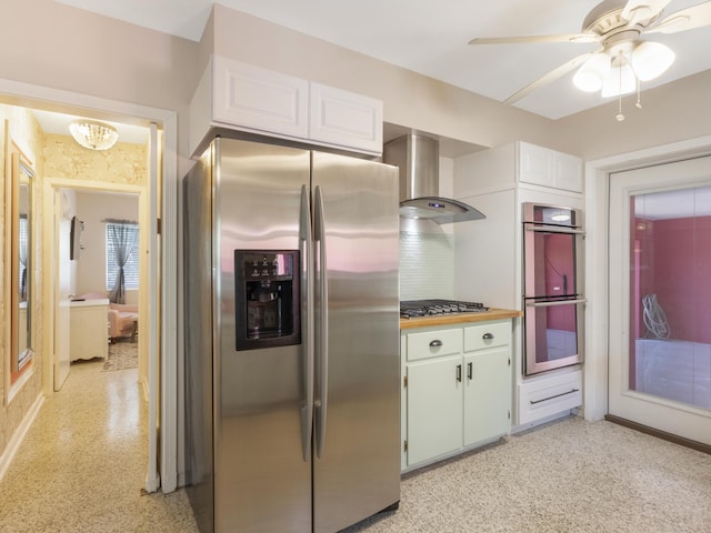 1001 N Lakeside Dr, Lake Worth Beach, FL 33460 - kitchen with appliances with stainless steel finishes, wall chimney exhaust hood, white cabinetry, a ceiling fan, and backsplash