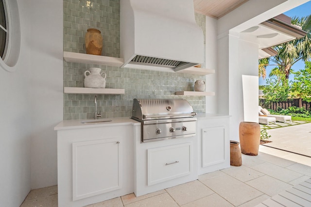 bar with a sink, decorative backsplash, wall chimney exhaust hood, and healthy amount of natural light