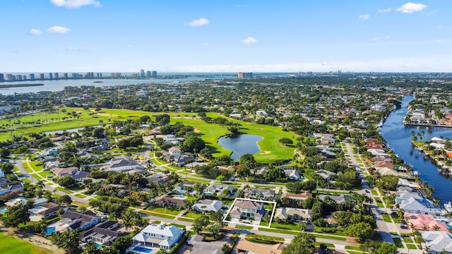 view of urban area featuring a large body of water, a golf course, nearby suburban area, and property parcel outlined