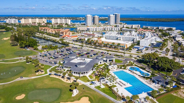 view of urban area featuring a nearby body of water, a pool, and a golf club