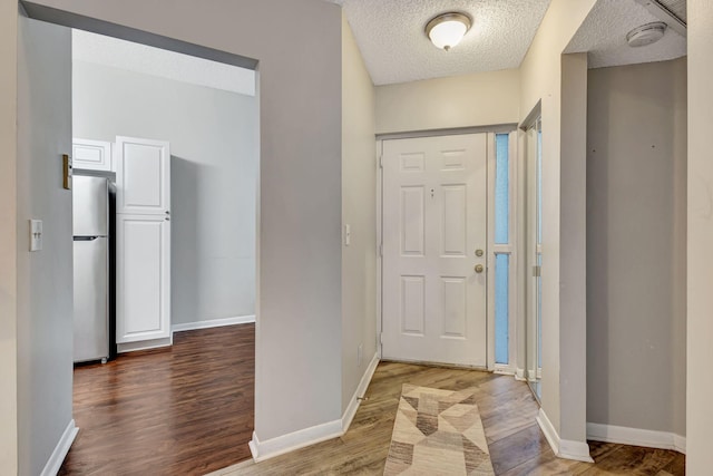 5450 Verona Dr Unit L, Boynton Beach, FL 33437 - foyer with wood finished floors, a textured ceiling, and baseboards