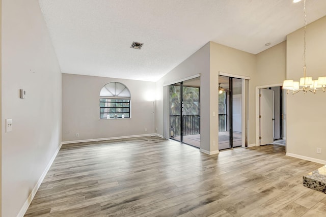 5450 Verona Dr Unit L, Boynton Beach, FL 33437 - unfurnished room with a chandelier, light wood finished floors, baseboards, and lofted ceiling