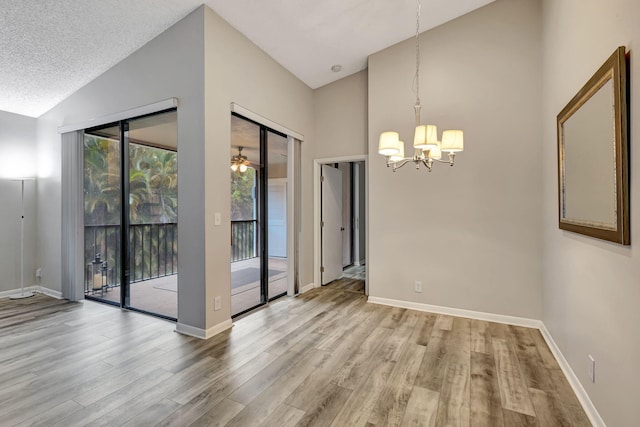 5450 Verona Dr Unit L, Boynton Beach, FL 33437 - unfurnished dining area featuring a chandelier, wood finished floors, baseboards, and high vaulted ceiling