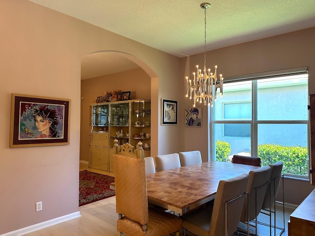 473 Cottagewood Ln, West Palm Beach, FL 33411 - dining space featuring arched walkways, plenty of natural light, a chandelier, baseboards, and a textured ceiling
