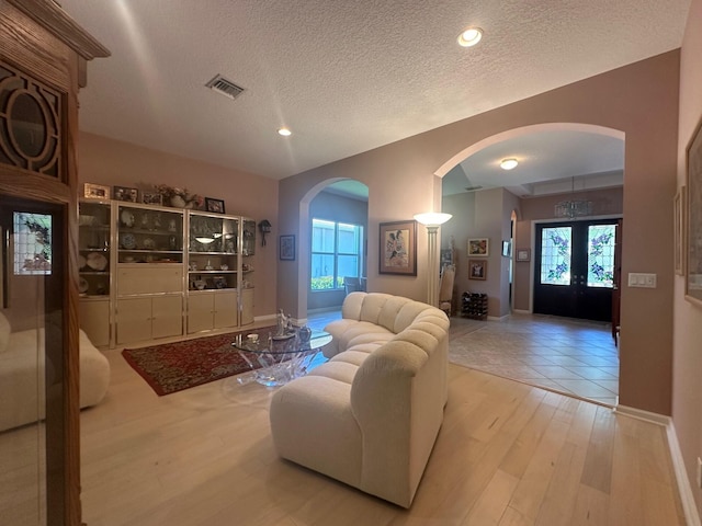 473 Cottagewood Ln, West Palm Beach, FL 33411 - living room featuring arched walkways, wood finished floors, a textured ceiling, baseboards, and recessed lighting