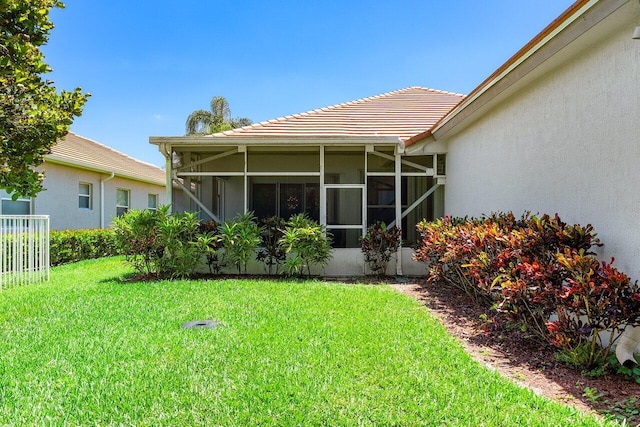 473 Cottagewood Ln, West Palm Beach, FL 33411 - rear view of property with a tile roof, stucco siding, a sunroom, and a yard