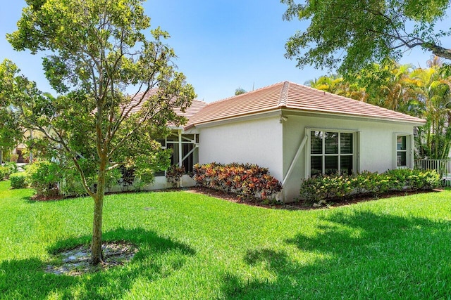 473 Cottagewood Ln, West Palm Beach, FL 33411 - view of side of property featuring a tile roof, a yard, and stucco siding